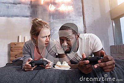 Overjoyed couple eating cupcakes and playing games Stock Photo