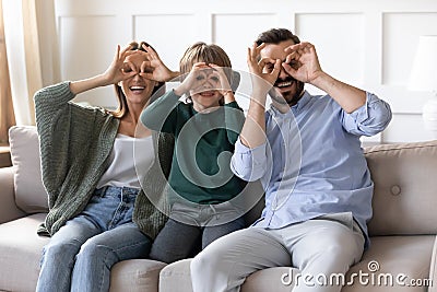 Overjoyed couple playing tricks fool with son at home. Stock Photo