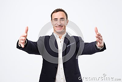 Overjoyed happy man in suit standing with his hands wide open welcoming his parners or friends Stock Photo