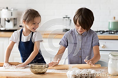 Overjoyed little children siblings playing with flour in kitchen. Stock Photo