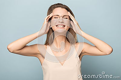 Overjoyed millennial woman in glasses laughing in studio Stock Photo