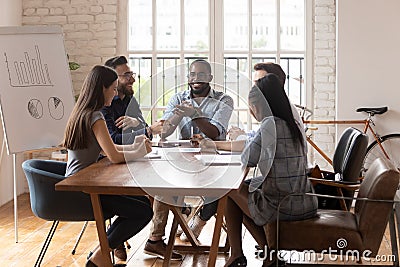 Smiling diverse colleagues brainstorm laugh at office meeting Stock Photo