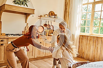 overjoyed parents playing with cute daughter Stock Photo