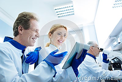Overjoyed smiling scientists looking at the tablet Stock Photo