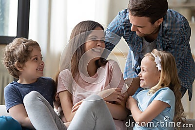 Overjoyed young family have fun relaxing together at home Stock Photo