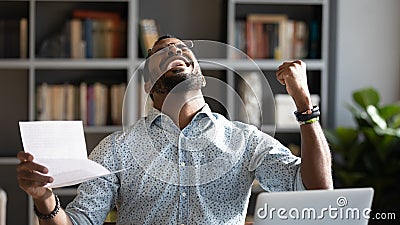 Overjoyed young mixed race man celebrating unbelievable triumph. Stock Photo