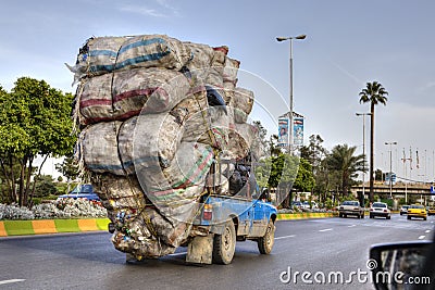 Overloaded with bags of waste, vehicle moves on higway, Iran Editorial Stock Photo