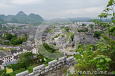 Overlook from stone wall to ancient town in mountains on cloudy Stock Photo