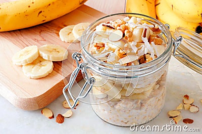 Overnight oats with bananas and nuts on white marble Stock Photo