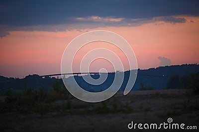 Overpass across the river against a pink sky. Stock Photo