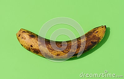 Overripe yellow banana on a green background, top view Stock Photo