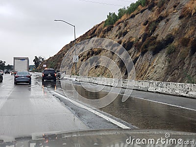 Overturned car and Highway Patrol on rain soaked freeway Editorial Stock Photo