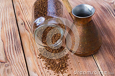 Overturned cezve with coffee beans, bowl with ground coffee on wooden table Stock Photo