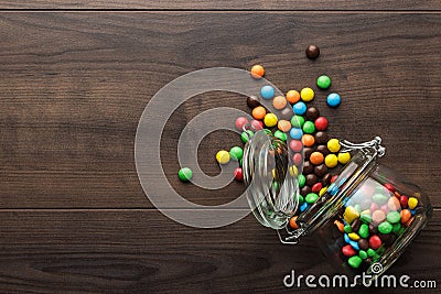 Overturned glass jar full of colorful sweets Stock Photo