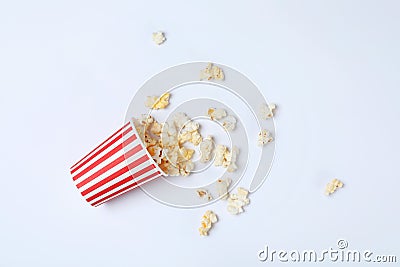 Overturned paper cup with tasty popcorn on white background Stock Photo