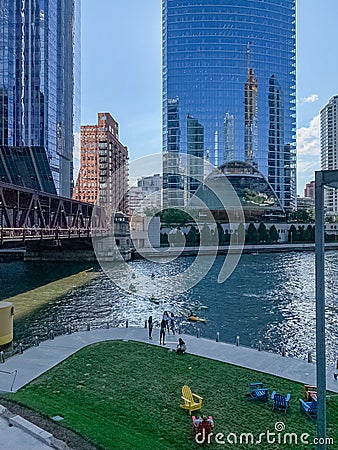 Overview of Chicago Loop recreation park where kayaks cross river, tourists walk riverwalk and relax on colorful chairs Editorial Stock Photo