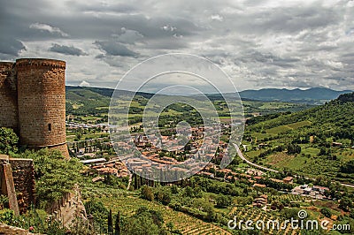 Overview of stone tower, green hills, vineyards and town rooftops near a road. From the city center of Orvieto. Stock Photo