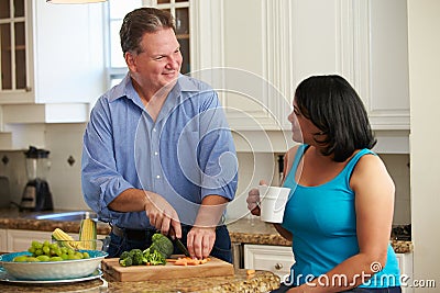 Overweight Couple On Diet Preparing Vegetables In Kitchen Stock Photo