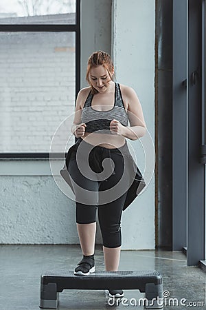 Overweight girl jumping on step platform Stock Photo