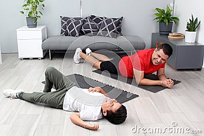 Overweight Latino dad and son exercise at home to lose weight and be healthy to avoid diseases such as diabetes or hypertension Stock Photo