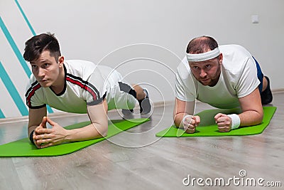 An overweight man is stressed to the limit while standing in the bar during fitness group classes Stock Photo