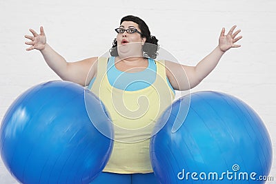 Overweight Woman Dropping Two Exercise Balls Stock Photo