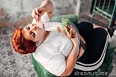 Overweight woman eats sandwich, bulimic, obesity Stock Photo