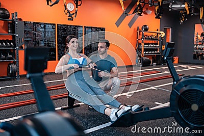 Overweight woman feeling excited exercising near trainer Stock Photo
