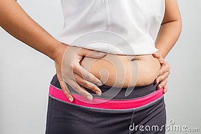 Overweight woman hand pinching excessive belly fat Stock Photo