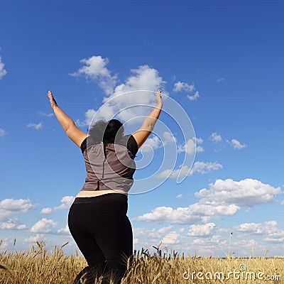 Overweight woman jumping at sky background Stock Photo