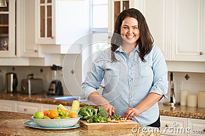 Overweight Woman Preparing Vegetables in Kitchen Stock Photo