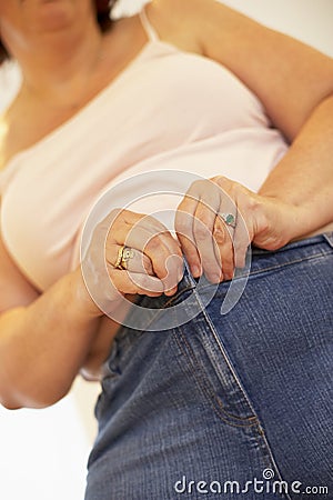 Overweight Woman Trying To Fasten Trousers Stock Photo