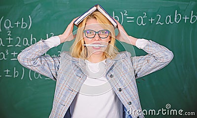 Overwork and lack of support driving teacher out of profession. Teacher woman with book chalkboard background. Why Stock Photo