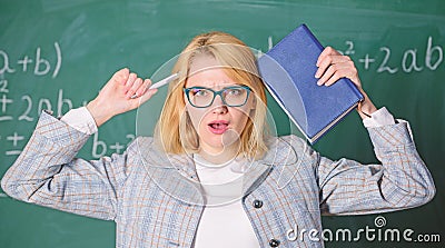 Overwork and lack of support driving teacher out of profession. Teacher woman with book chalkboard background. Why Stock Photo