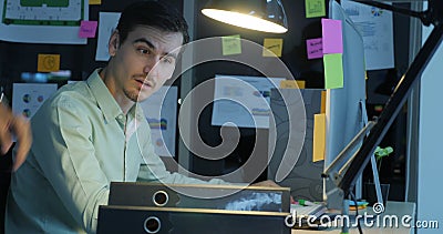Overworked businessman working late at night in the office. stock footage Overworked businessman working late at night in the office. stock footage