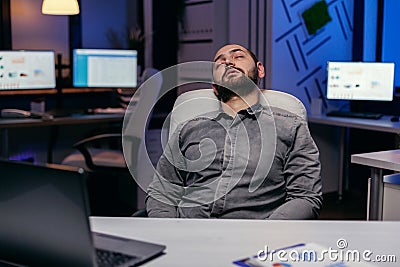 Overworked exhausted man sleeps on chair Stock Photo