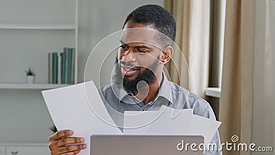 Overworked millennial ethnic male office worker stressed by paperwork. Angry depressed annoyed African American Stock Photo