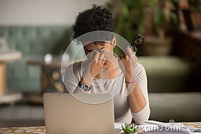 Overworked tired african woman holding glasses feel eye strain Stock Photo