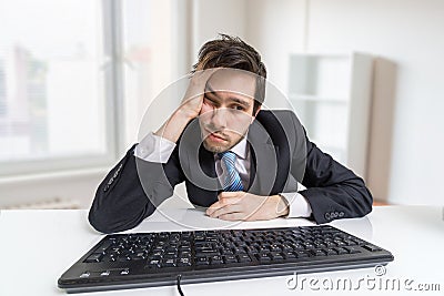 Overworked and tired businessman is working with computer in office Stock Photo