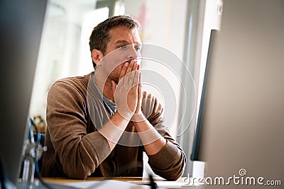 Overworked tired employee, programmer at workplace in office being unhappy Stock Photo