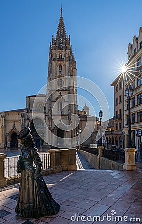 View of the La Regenta statue and San Salvador Cathedral in the historic city center of Oviedo with a sunburst Editorial Stock Photo