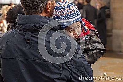 A sleepy Asian kid on his fathers arms Editorial Stock Photo