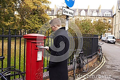 OXFORD/ UK- OCTOBER 26 2016: Man Posting Letter In Royal Mail Postbox Stock Photo