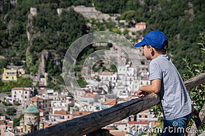 Ð’oy looks into the distance. Rest, walking, children`s, family tourism. Beautiful view of the Amalfi Coast. Italian summer resor Stock Photo