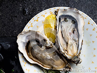 Oysters heart shape in plate, lemon, shells on marble. Delicacy super food, rich in antioxidants, vitamin, zinc Stock Photo