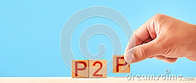 p2p concept. man stacks wooden blocks with the inscription p2p. Stock Photo