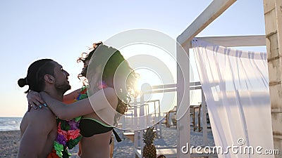 Paare in Hawaii auf Sommer stehen, die Männer still, die Frauen in der Hintergrundbeleuchtung, Freunde mit bunten Kränzen auf Küs stock video Paare in Hawaii auf Sommer stehen, die Männer still, die Frauen in der Hintergrundbeleuchtung, Freunde mit bunten Kränzen auf Küs stock video