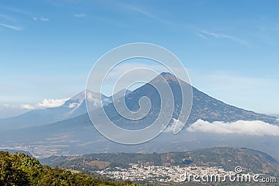 Pacaya Volcano hike tour. Panoramic view of volcano Fuego Acatenango and agua with village below Stock Photo