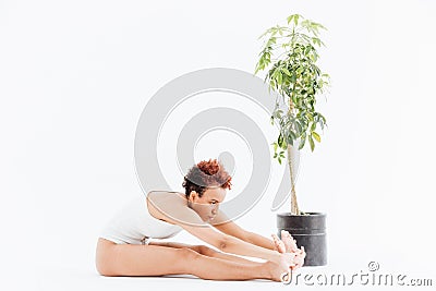 Pacified african american young woman stretching and practicing yoga Stock Photo