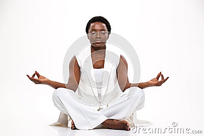 Pacified pretty african woman sitting and meditating in lotus pose Stock Photo